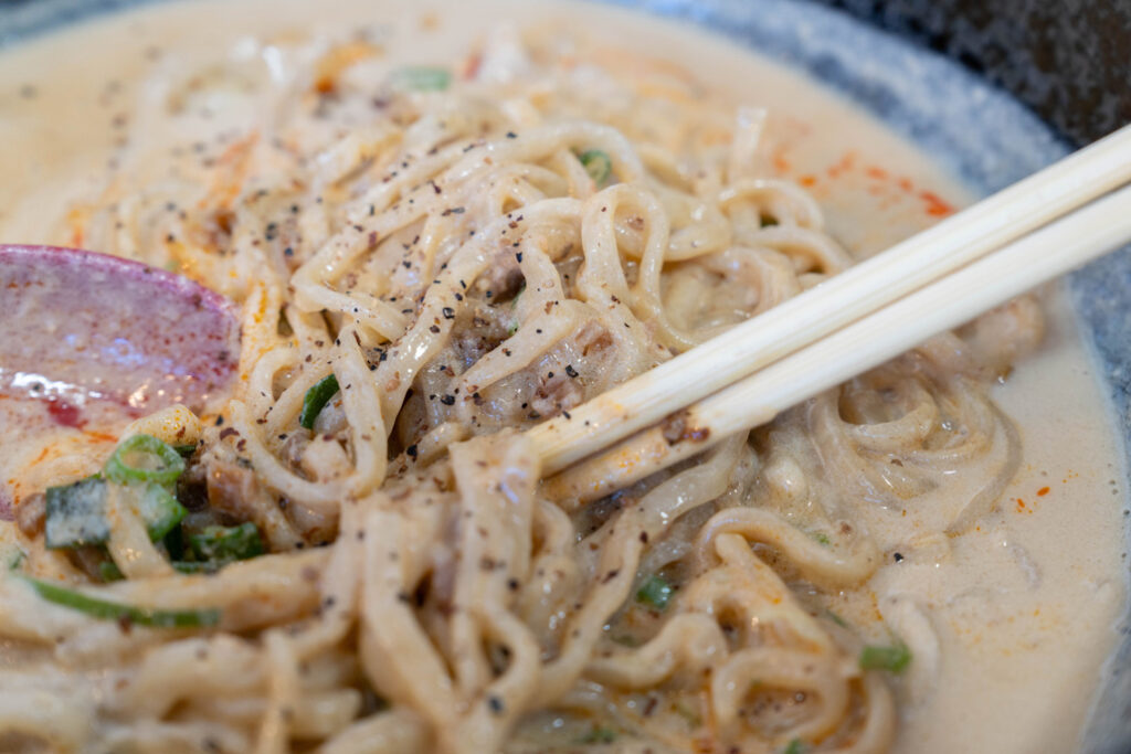 「担々麺 三国志 六地蔵店」で担々麺の味変している画像